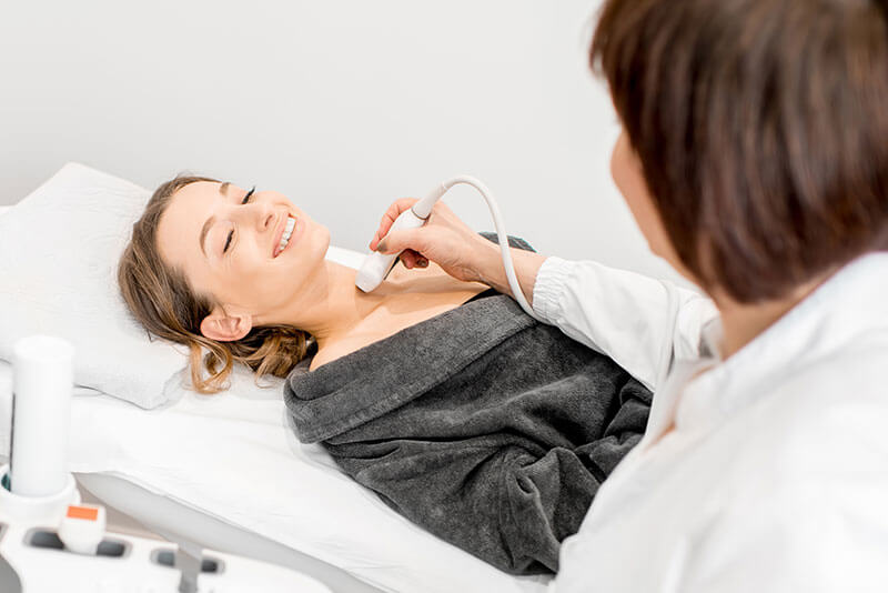 woman getting thyroid scan